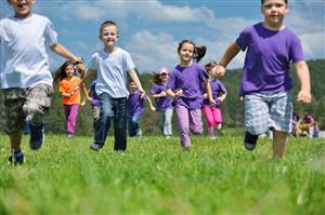 Pre-school aged children enjoying a run across a field