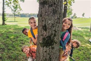 6 Older kids peeking out from behind a tree